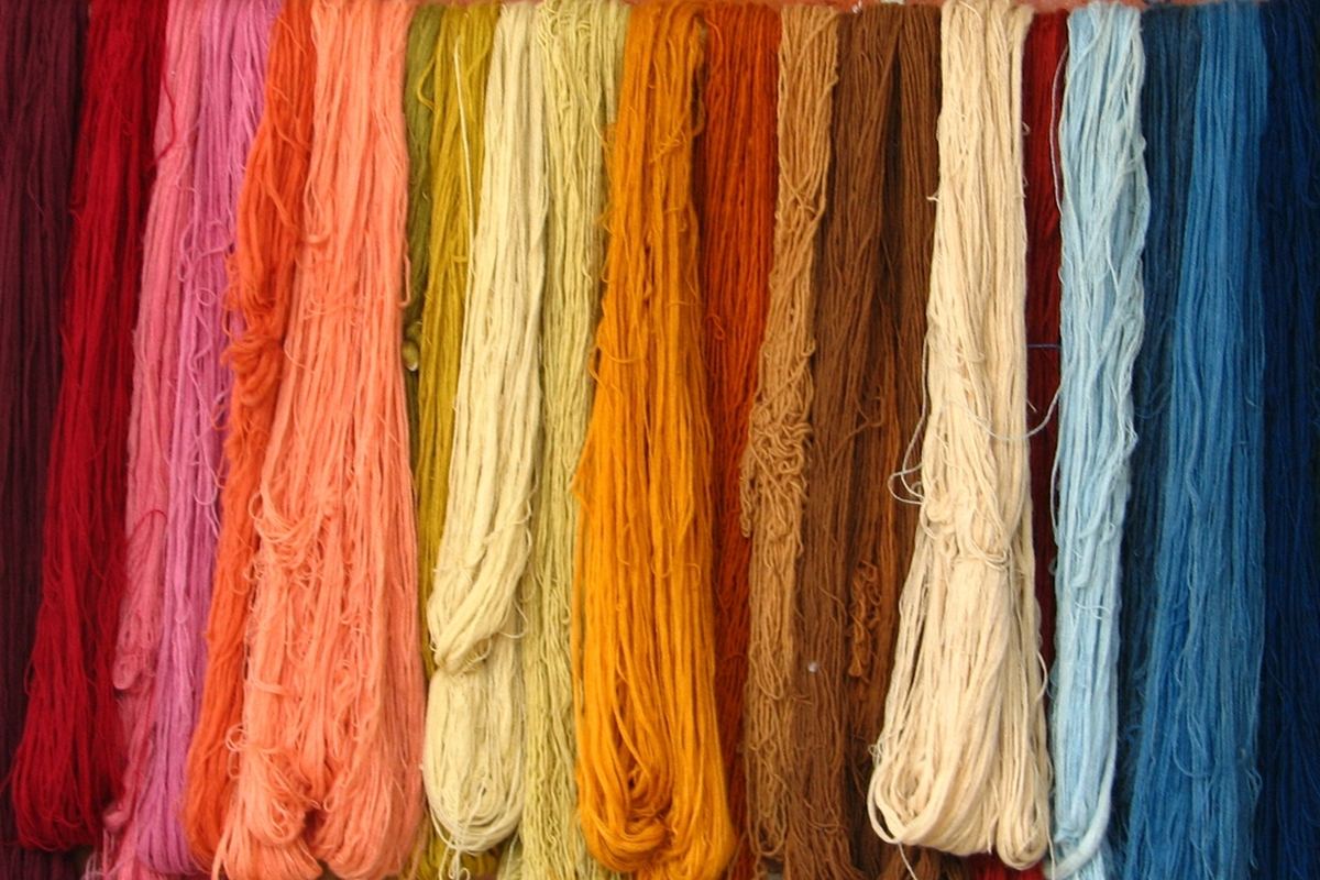 Madejas de hilo teñidas en muchos colores colgadas una junto a otra